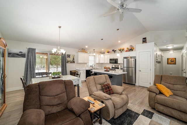 living room featuring vaulted ceiling, sink, ceiling fan with notable chandelier, and light wood-type flooring