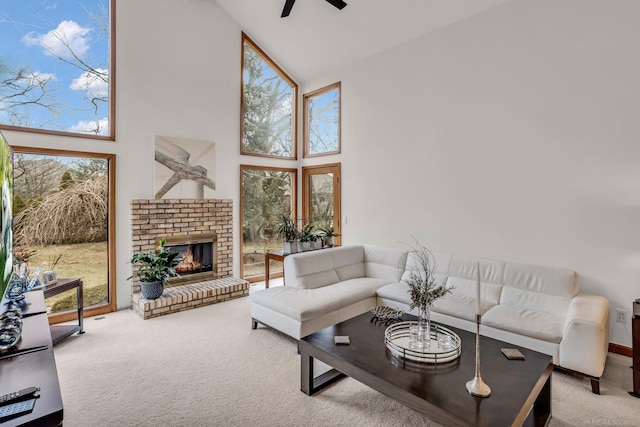 carpeted living room with a brick fireplace, high vaulted ceiling, and ceiling fan