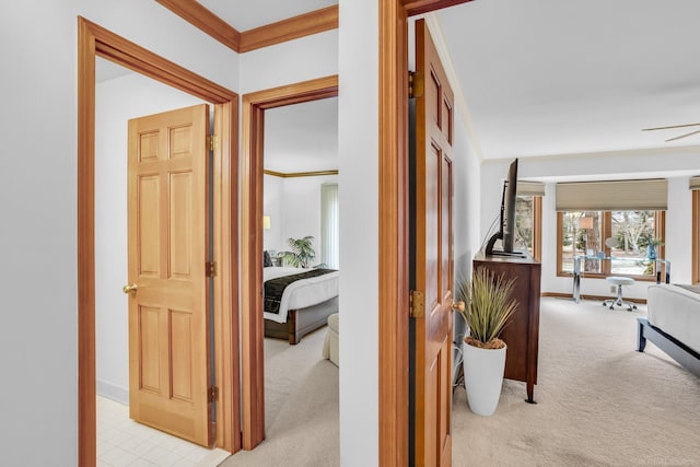 corridor featuring ornamental molding and light colored carpet