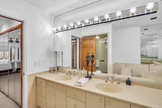 bathroom featuring ornamental molding, tiled shower, vanity, and toilet