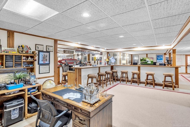 office area with bar, light carpet, and a paneled ceiling