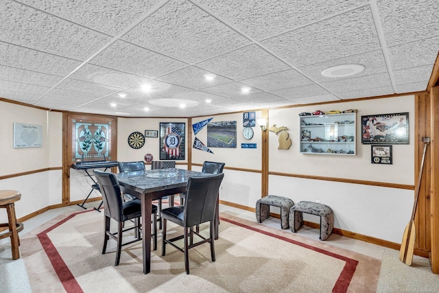 dining room featuring a drop ceiling and carpet floors