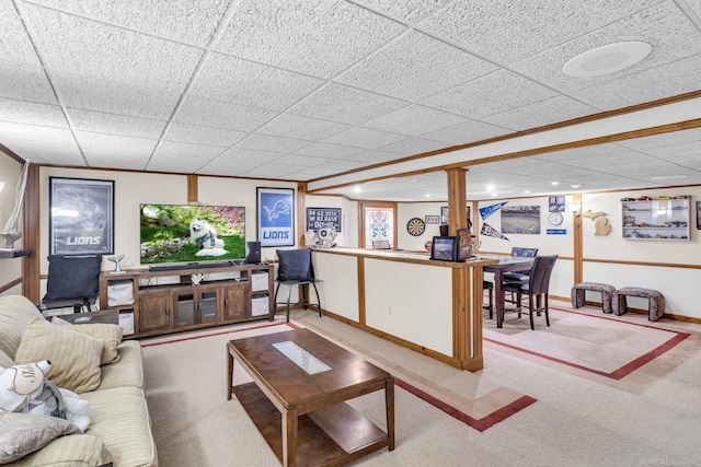 living room featuring a drop ceiling and light colored carpet