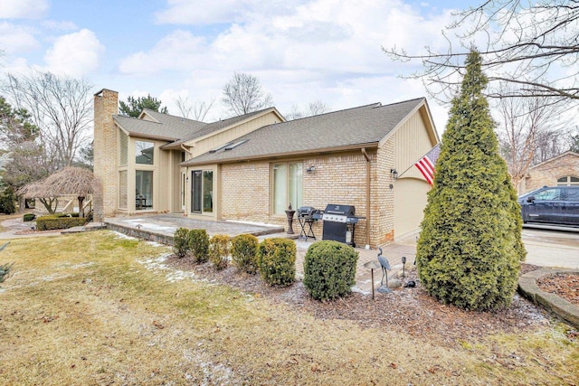 rear view of property with a gazebo, a lawn, and a patio