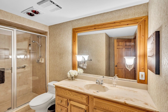 bathroom featuring vanity, toilet, and a shower with door