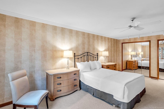 carpeted bedroom with ornamental molding and ceiling fan