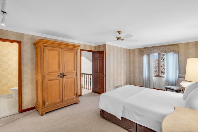 carpeted bedroom with connected bathroom, ornamental molding, and ceiling fan