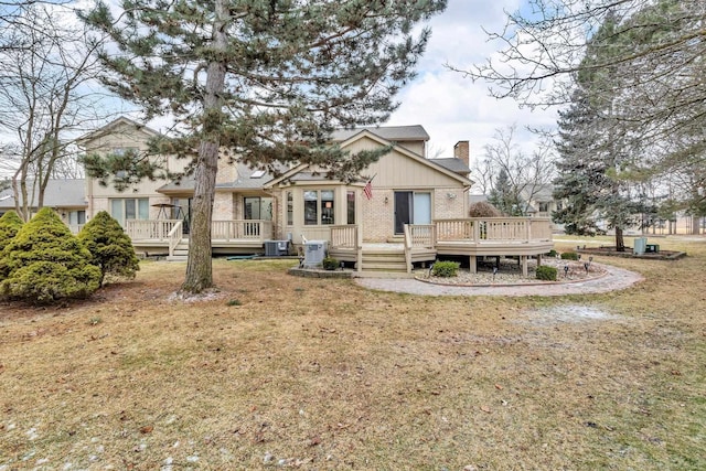 back of property featuring central AC unit, a yard, and a deck