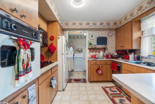 kitchen featuring washer / clothes dryer, black appliances, and sink