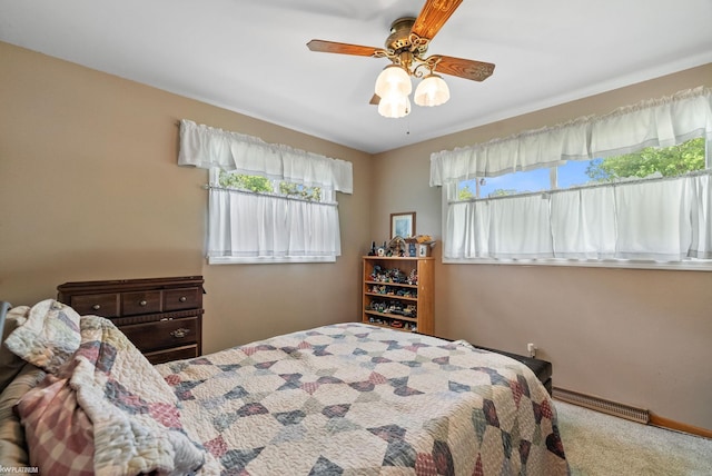 bedroom with ceiling fan, carpet floors, and multiple windows