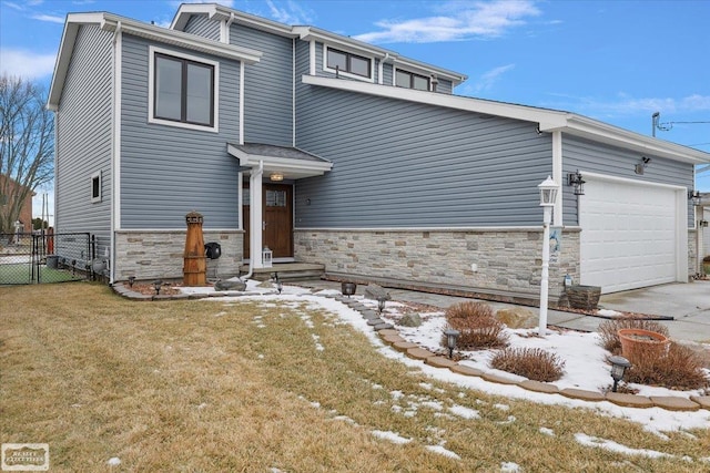 view of front of property with stone siding, a front lawn, an attached garage, and fence