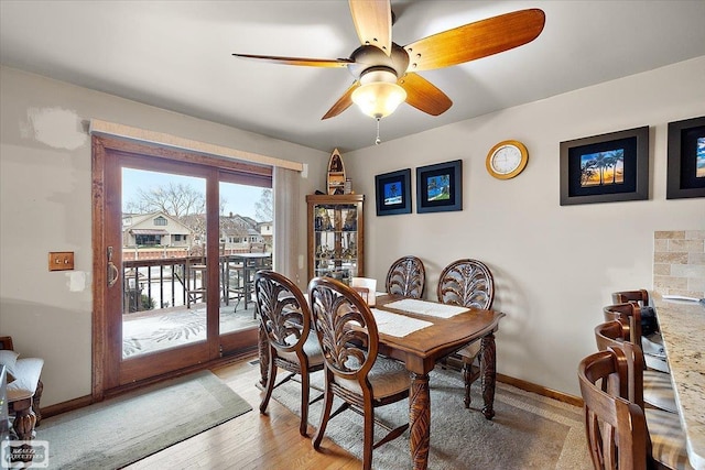 dining room with light wood-style flooring, baseboards, and ceiling fan