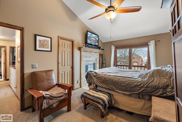 bedroom featuring high vaulted ceiling, a ceiling fan, a glass covered fireplace, baseboards, and light colored carpet