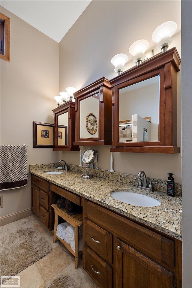 bathroom with tile patterned flooring, double vanity, baseboards, and a sink