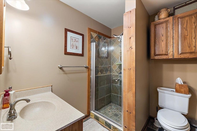 bathroom featuring toilet, a stall shower, and vanity