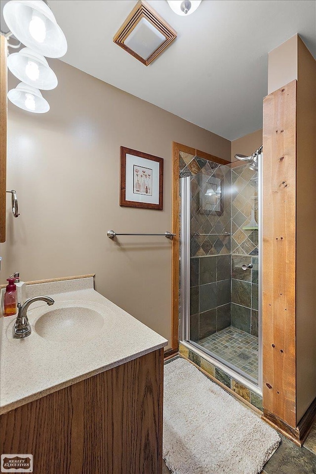 bathroom with vanity, a shower stall, and visible vents