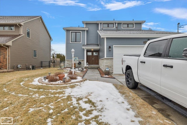 view of front of house with stone siding, cooling unit, an attached garage, and driveway