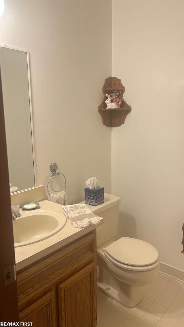 bathroom with tile patterned flooring, vanity, and toilet