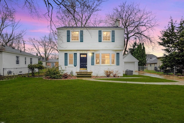 view of front facade with a garage, an outbuilding, a yard, and central AC