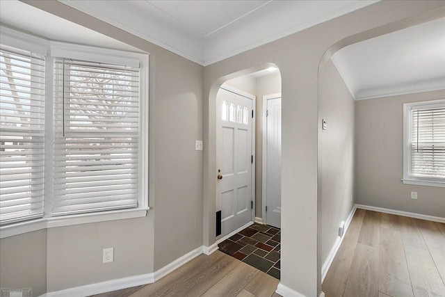 foyer entrance featuring ornamental molding and dark wood-type flooring