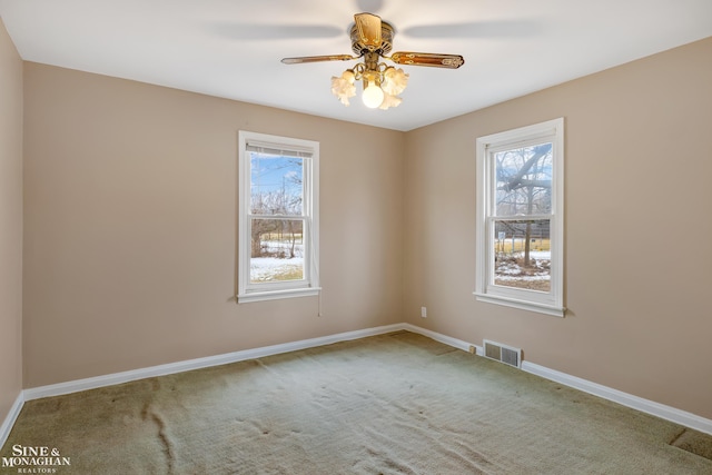 spare room with a healthy amount of sunlight, ceiling fan, and carpet flooring