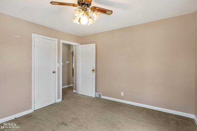 carpeted spare room featuring ceiling fan