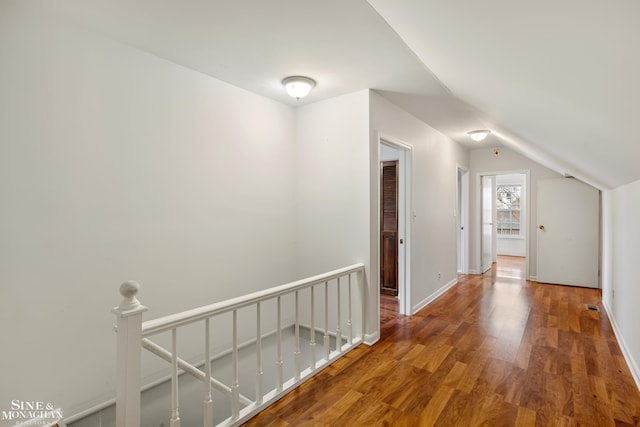 corridor featuring wood-type flooring and lofted ceiling