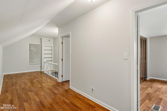 additional living space featuring lofted ceiling and hardwood / wood-style floors