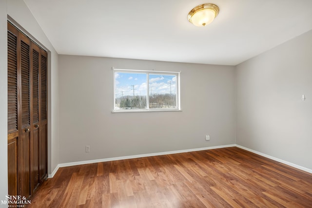 unfurnished bedroom featuring wood-type flooring and a closet