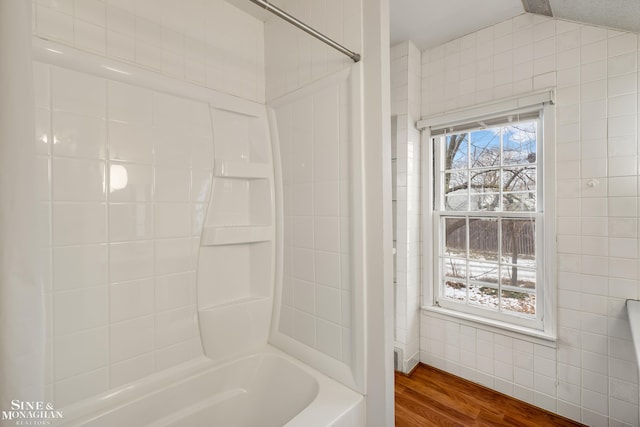 bathroom with lofted ceiling, wood-type flooring, and bathtub / shower combination