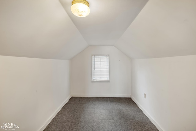 bonus room with vaulted ceiling and carpet flooring