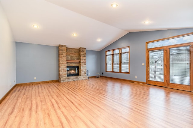 unfurnished living room featuring a fireplace, light hardwood / wood-style floors, and vaulted ceiling