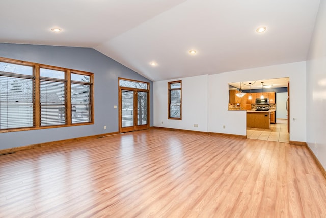 unfurnished living room featuring vaulted ceiling and light wood-type flooring