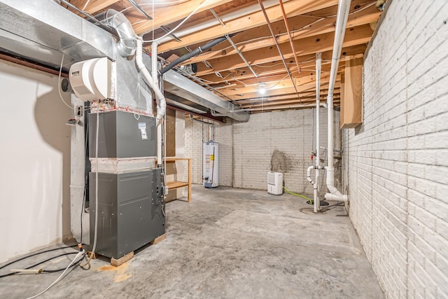 basement with brick wall, heating unit, and gas water heater