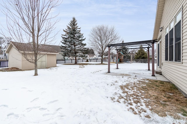 yard layered in snow with a storage shed, a pergola, and a playground