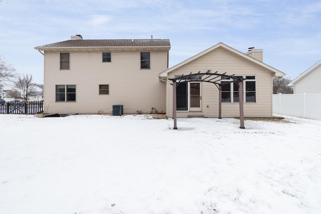 snow covered rear of property featuring cooling unit and a pergola