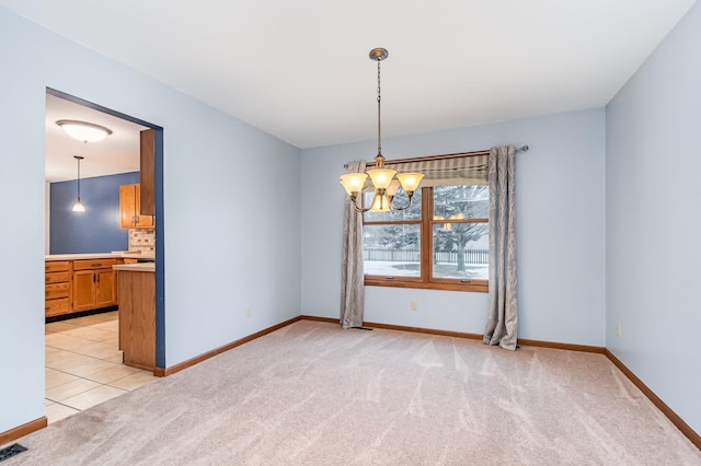 carpeted spare room with a notable chandelier