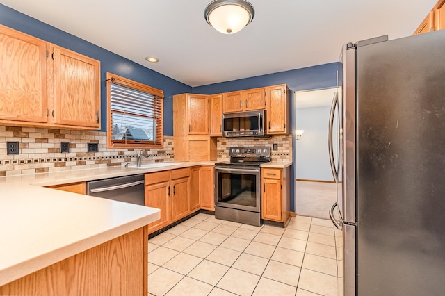 kitchen with appliances with stainless steel finishes, sink, decorative backsplash, and light tile patterned floors