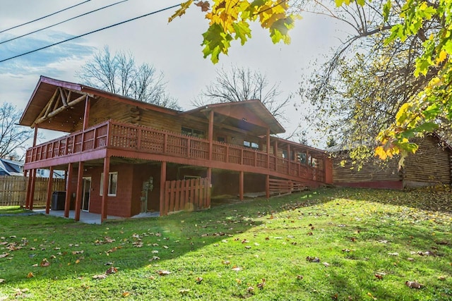 back of house with cooling unit, a deck, and a lawn