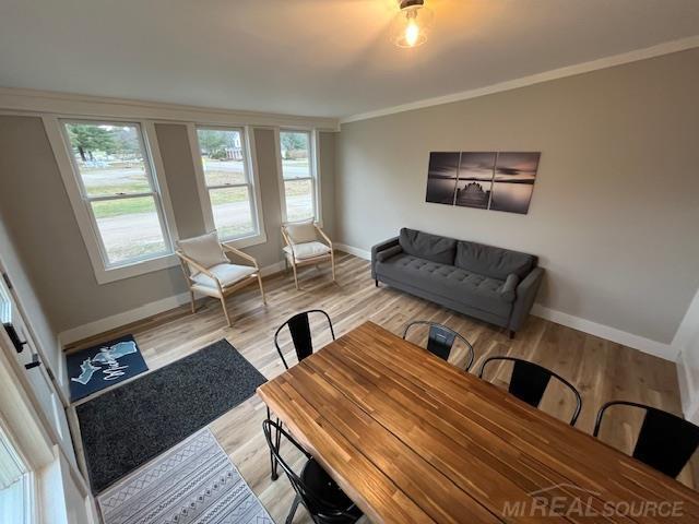 living room featuring light hardwood / wood-style flooring and ornamental molding