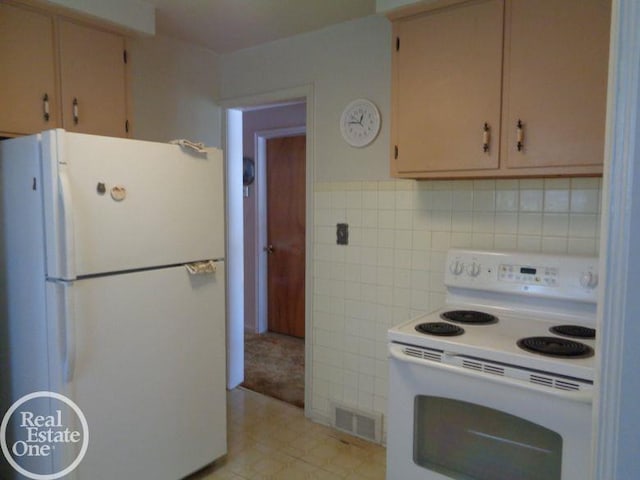 kitchen with light tile patterned flooring, white appliances, and tile walls