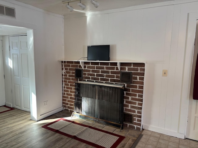 interior details featuring visible vents, a brick fireplace, and rail lighting