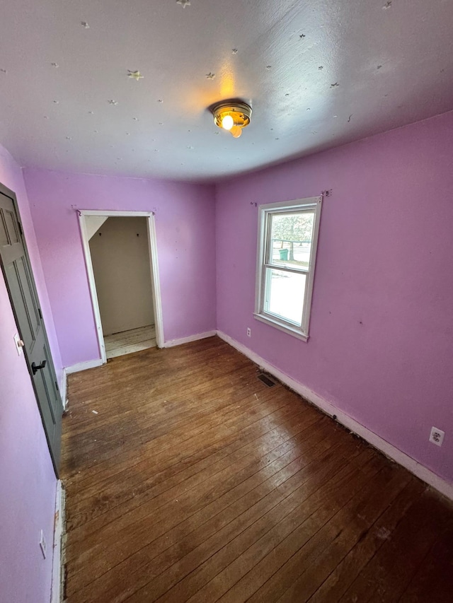 58400 William St, New Haven, MI 48048 - unfurnished bedroom featuring dark wood-type flooring