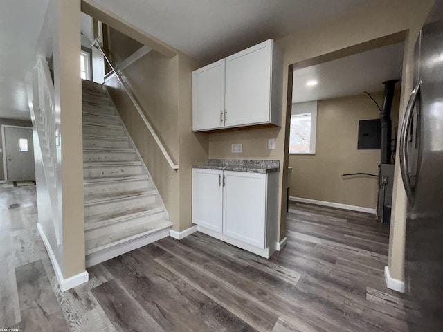 stairs with wood-type flooring and electric panel