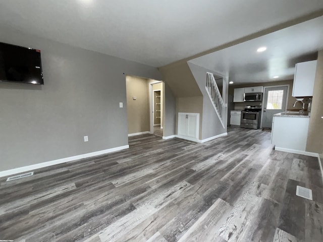 unfurnished living room with dark wood-type flooring and sink