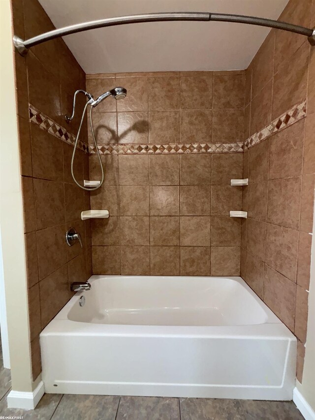bathroom featuring tiled shower / bath combo and tile patterned flooring
