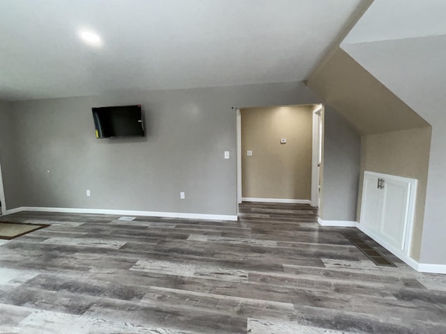 additional living space featuring vaulted ceiling and dark hardwood / wood-style floors