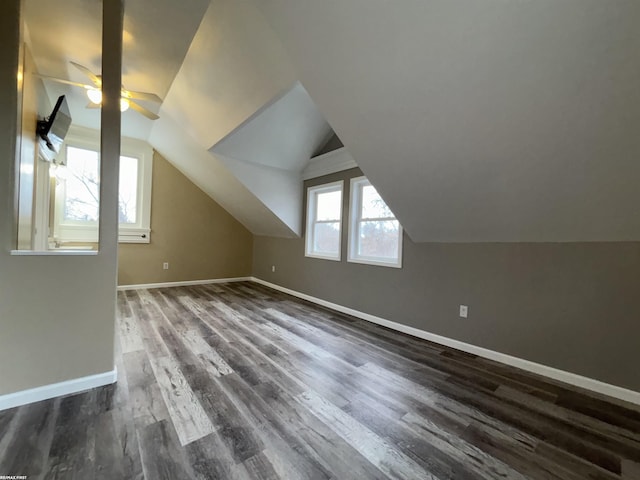additional living space with vaulted ceiling, dark hardwood / wood-style floors, and ceiling fan