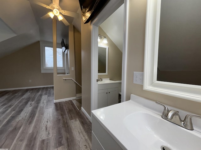 bathroom featuring hardwood / wood-style flooring, vanity, and lofted ceiling