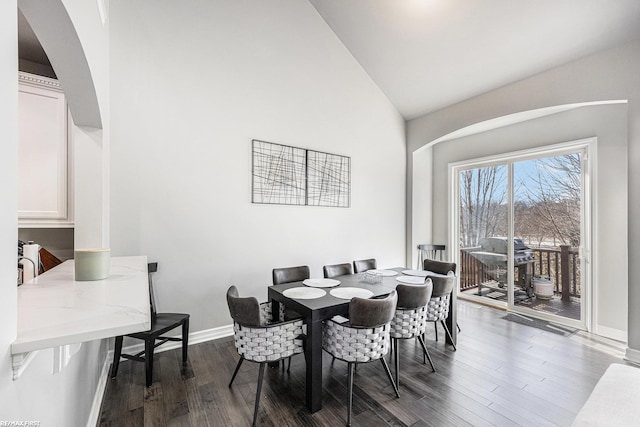 dining room featuring lofted ceiling and dark hardwood / wood-style floors